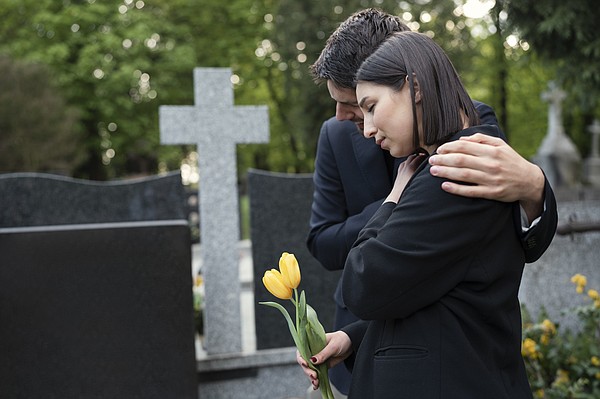 BRV mourning woman cemetery being consoled by man_t600