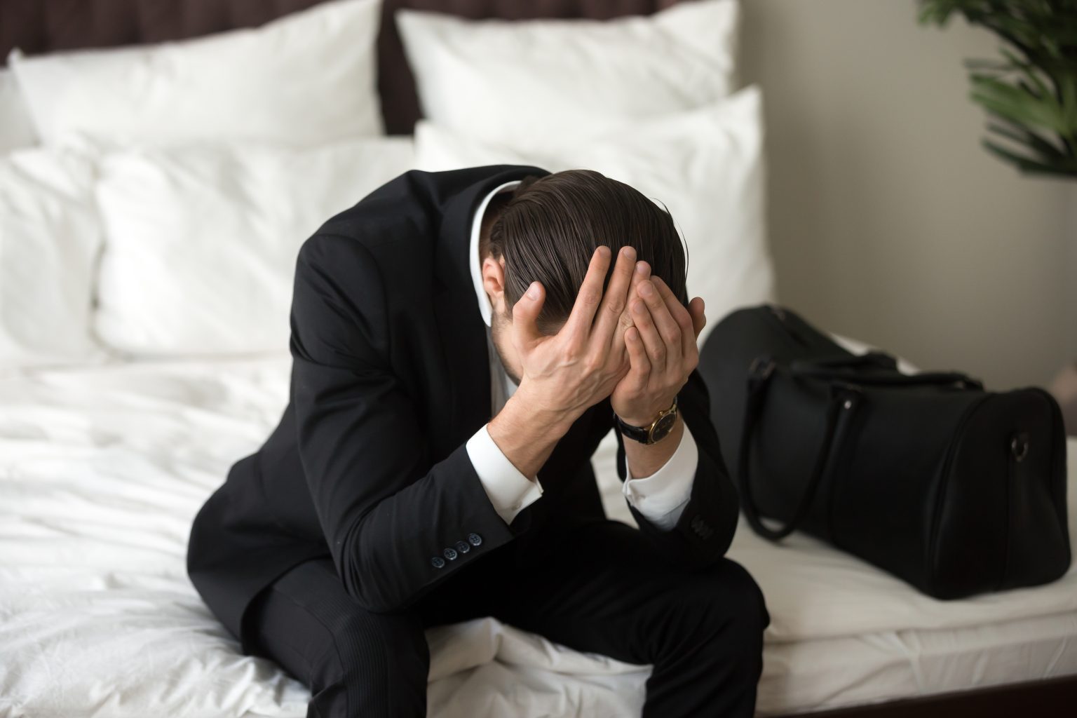stressed upset businessman sitting bed having headache 1536x1024 2